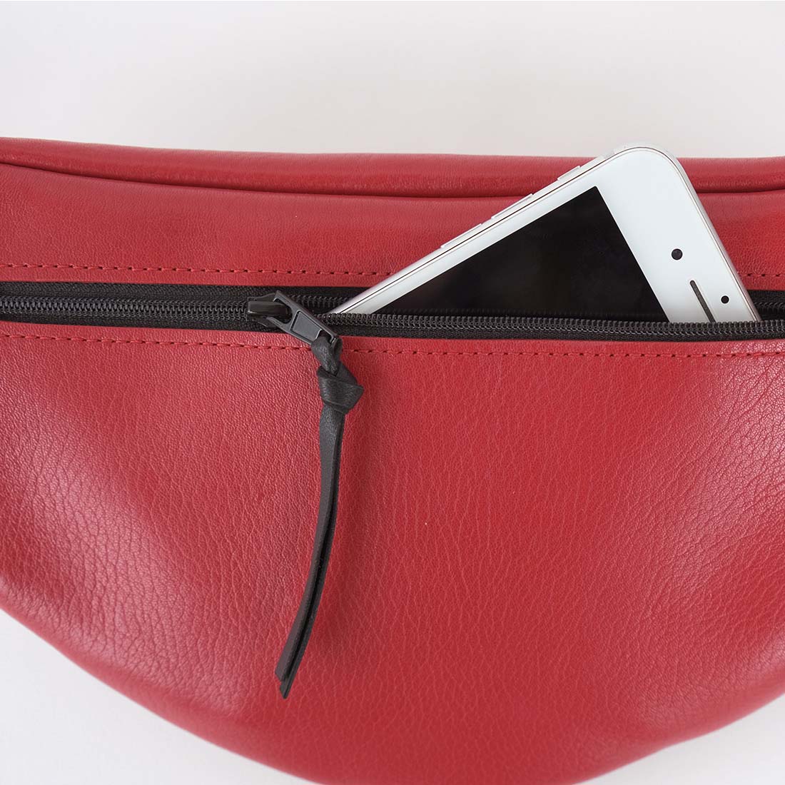 Sac banane mini format en cuir de veau coloris cerise.