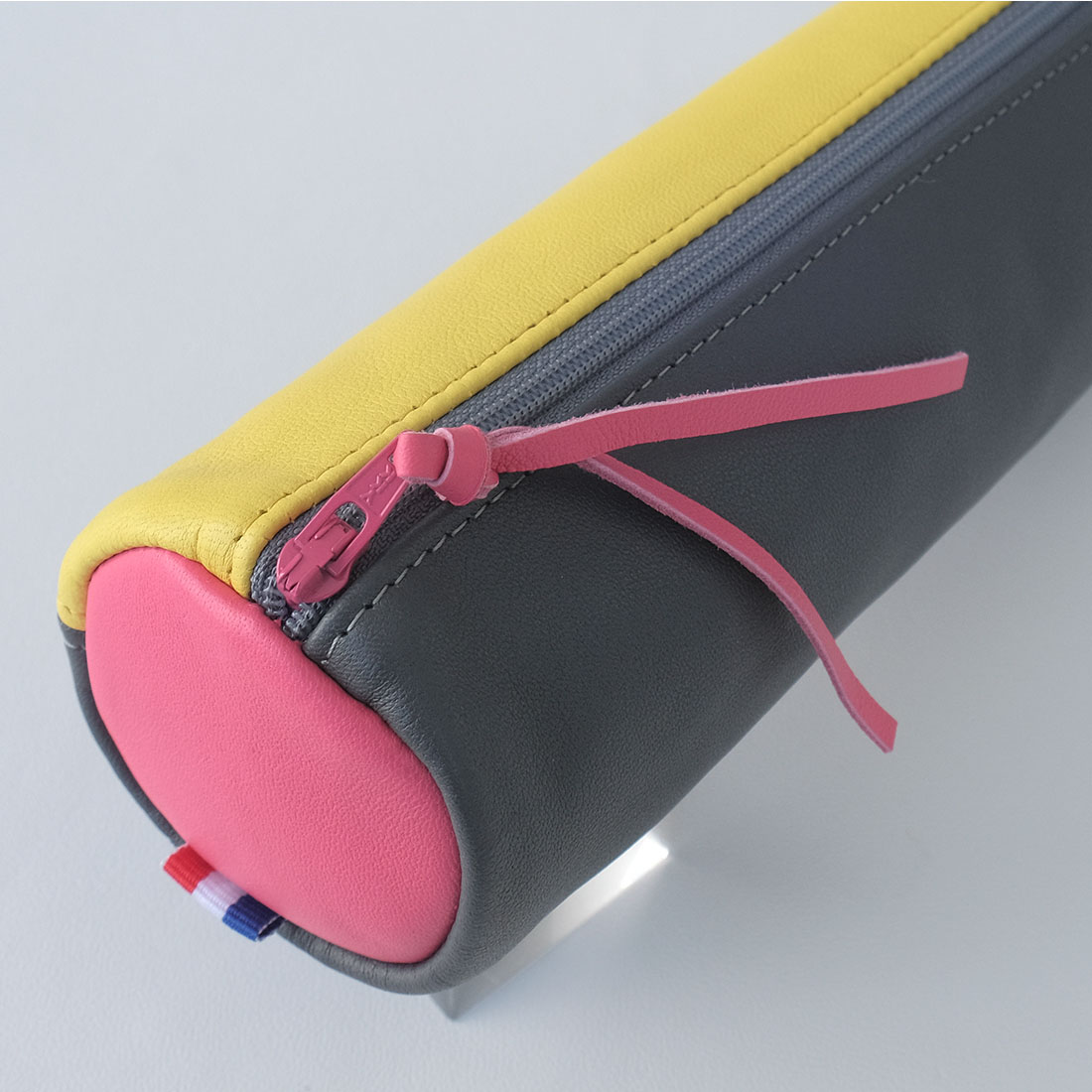 Trousse ronde en cuir gris jaune rose